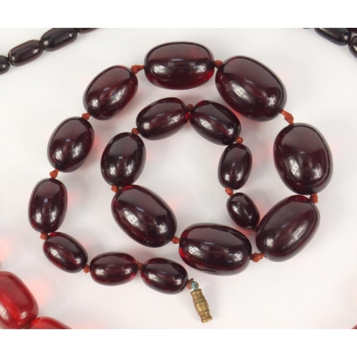 781 - Two cherry amber coloured bead necklaces, the largest 90cm in length, 147.0g