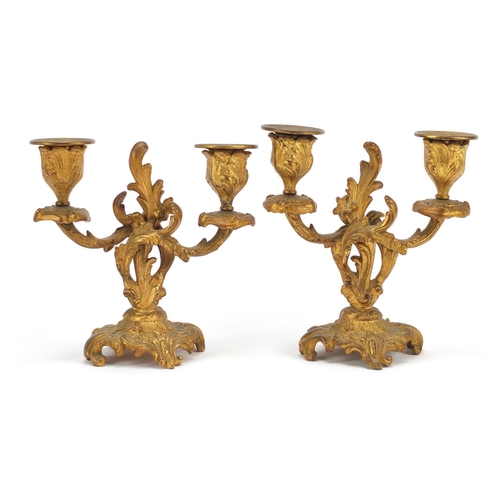 52 - Pair of Rococco gilt metal two branch candlesticks, each 15cm high