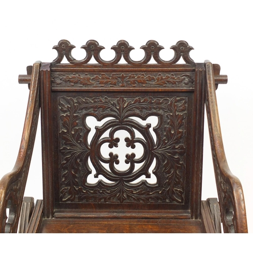 2033 - Gothic style oak hall chair with X-frame support carved with foliage, 88cm high