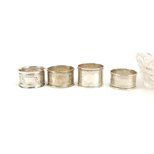 2504 - Four silver napkin rings and a cut glass claret jug with silver plated mounts, the largest 23cm high