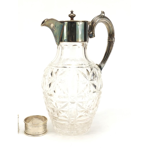 2504 - Four silver napkin rings and a cut glass claret jug with silver plated mounts, the largest 23cm high