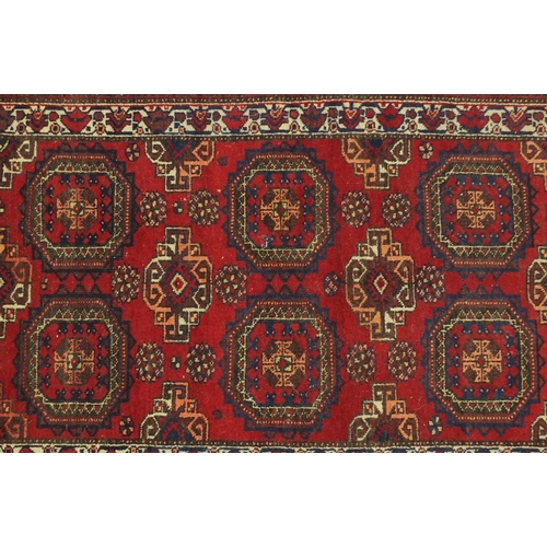 4 - Rectangular Oranda rug, having an all over geometric design onto a red ground, 175cm x 90cm