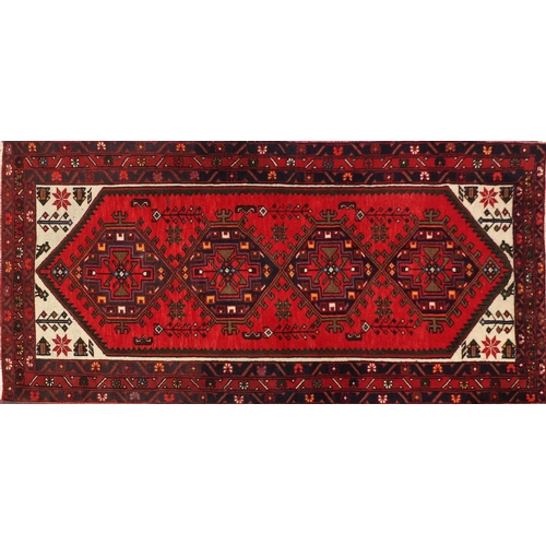 2061 - Rectangular Persian red ground rug having an all over geometric design, 200cm x 101cm