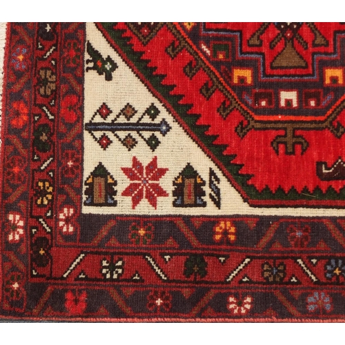 2061 - Rectangular Persian red ground rug having an all over geometric design, 200cm x 101cm