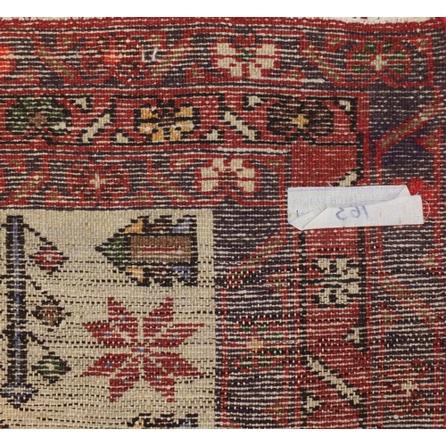 2061 - Rectangular Persian red ground rug having an all over geometric design, 200cm x 101cm