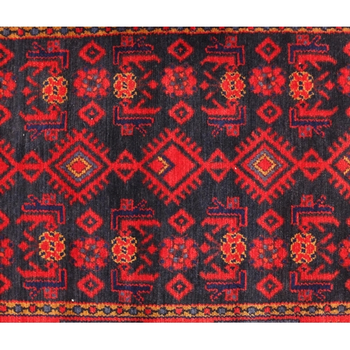 2067 - Rectangular Persian blue and red ground rug having a geometric design, 175cm x 115cm