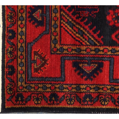 2067 - Rectangular Persian blue and red ground rug having a geometric design, 175cm x 115cm