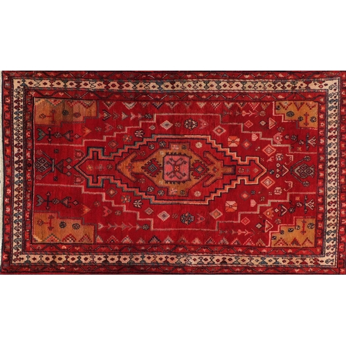 2055 - Rectangular Persian red ground rug having an all over geometric design, 210cm x 126cm
