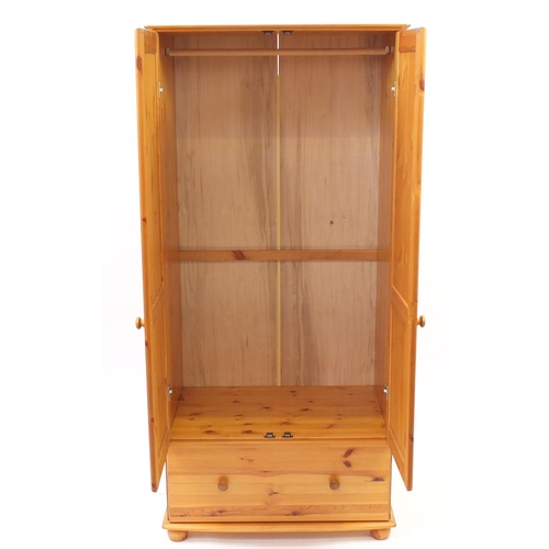 57 - Pine two door wardrobe with a drawer to the base, 186cm H x 84cm W x 55cm D