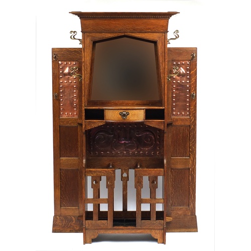 2005A - Arts & Crafts oak hall stand with bevelled mirror and copper inserts to each wing, remnants of the o... 