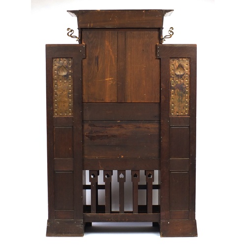 2005A - Arts & Crafts oak hall stand with bevelled mirror and copper inserts to each wing, remnants of the o... 