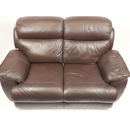 28 - Electric brown leather two seater reclining settee with a storage footstool, 165cm in length