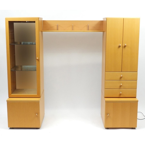 2130 - Beech illuminated wall unit by John Coyle, fitted with a series of cupboard doors, drawers and glass... 