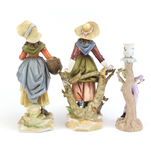 2606 - Pair of 19th century Continental porcelain figurines and a figural candlestick, the largest 29.5cm