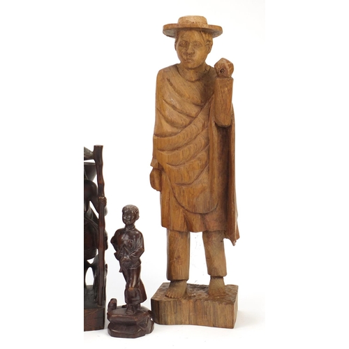 2421 - Three African carved wood figures and one of a Chinese boy, the largest 50cm high