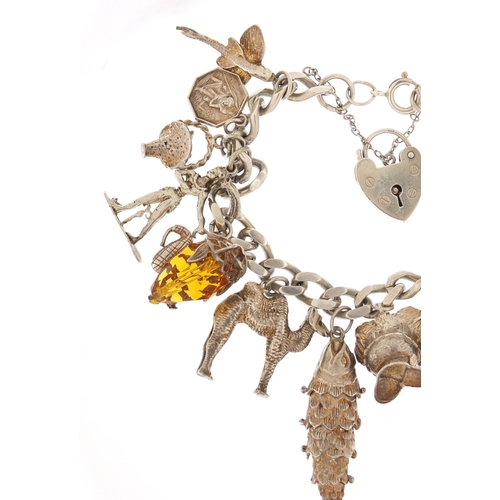 152 - Silver charm bracelet with a selection of mostly silver charms including articulated fish, camel and... 