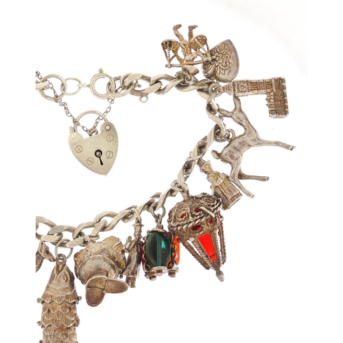 152 - Silver charm bracelet with a selection of mostly silver charms including articulated fish, camel and... 