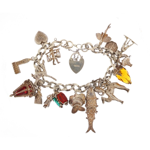 152 - Silver charm bracelet with a selection of mostly silver charms including articulated fish, camel and... 