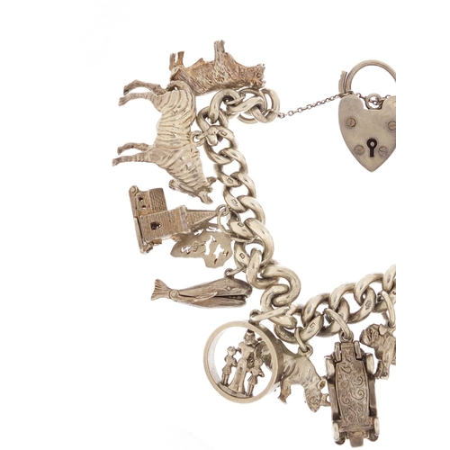 87 - Silver charm bracelet with a selection of mostly silver charms including bulldog, rhino, classic car... 