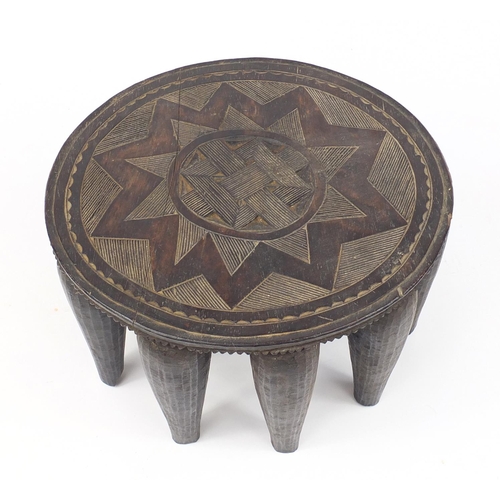 2111 - Tribal interest carved hardwood stool, 35.5cm in diameter