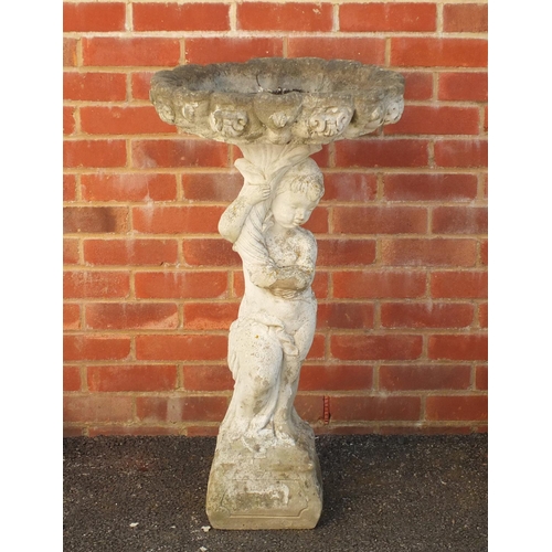 2143 - Stoneware garden birdbath in the form of a young figure holding a cornucopia, 90cm high