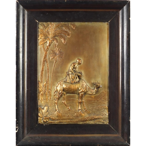 2578 - Coppered relief panel of an Egytian figure on camel back, framed, 38cm x 26cm