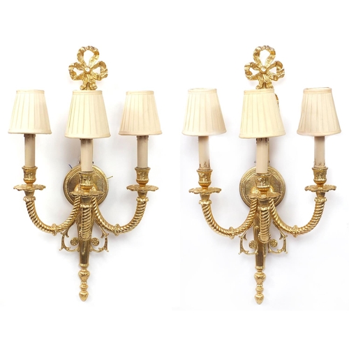 115 - Pair of Louis XVI style three branch brass wall sconces with shades, 67cm high