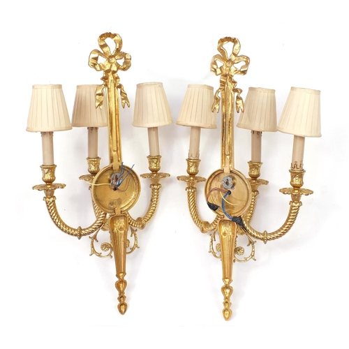 115 - Pair of Louis XVI style three branch brass wall sconces with shades, 67cm high