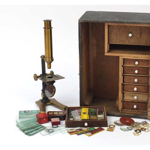 3179 - Victorian brass microscope and a small selection of student specimen glass slides, housed in a pine ... 