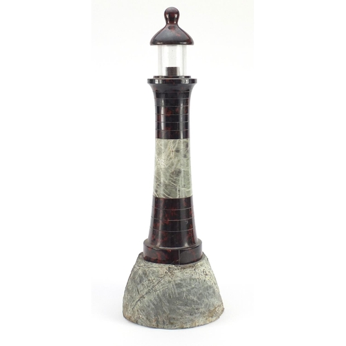 3608 - Large carved red serpentine marble lighthouse design lamp with rocky base, 56cm high