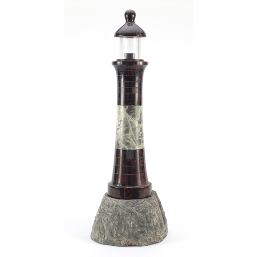 3608 - Large carved red serpentine marble lighthouse design lamp with rocky base, 56cm high