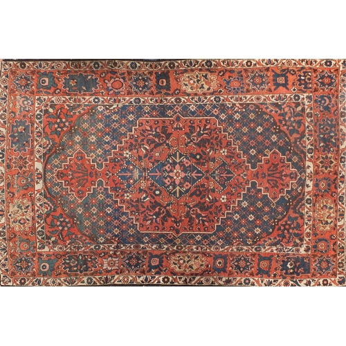 4015 - Rectangular Persian rug having an all over floral design onto a red and blue grounds, 216cm x 147cm