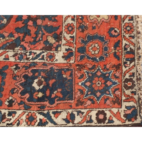 4015 - Rectangular Persian rug having an all over floral design onto a red and blue grounds, 216cm x 147cm