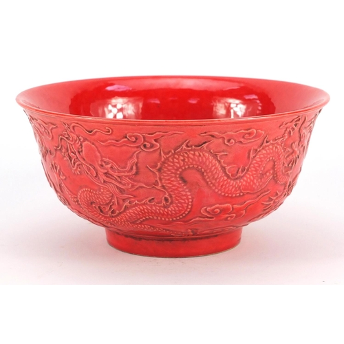 3380 - Chinese red ground porcelain bowl decorated in relief with dragons amongst clouds, six figure charac... 