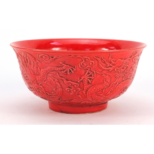 3380 - Chinese red ground porcelain bowl decorated in relief with dragons amongst clouds, six figure charac... 