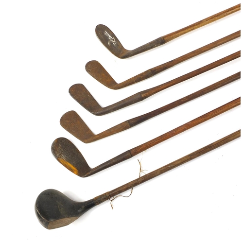 3341 - Six wooden shafted golf clubs, some with leather grips, including a driver