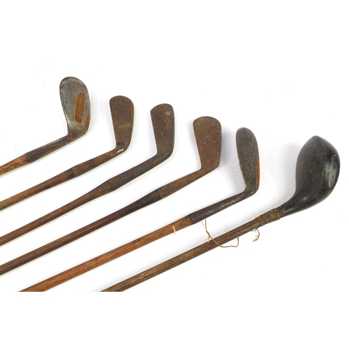 3341 - Six wooden shafted golf clubs, some with leather grips, including a driver