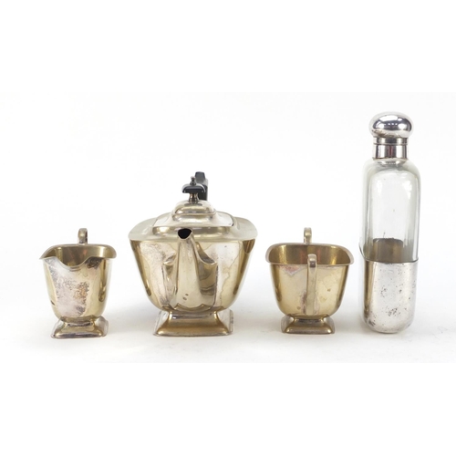 3767 - Silver plate comprising oversized glass hip flask by JDS & Sons and three piece teaset, the largest ... 