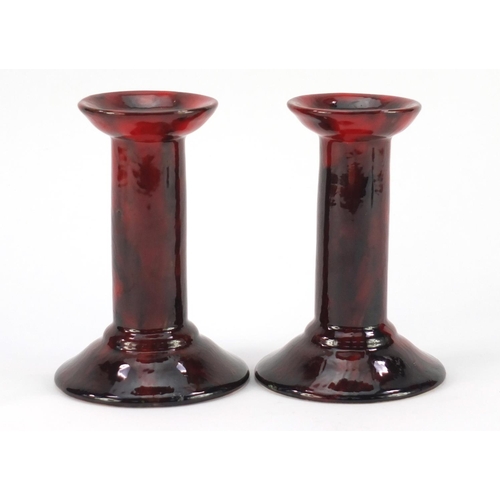 3484 - Pair of Royal Doulton flambe candlesticks by Charles Noke and Harry Nixon, each 14.5cm high