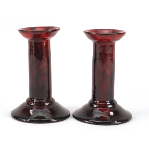 3484 - Pair of Royal Doulton flambe candlesticks by Charles Noke and Harry Nixon, each 14.5cm high