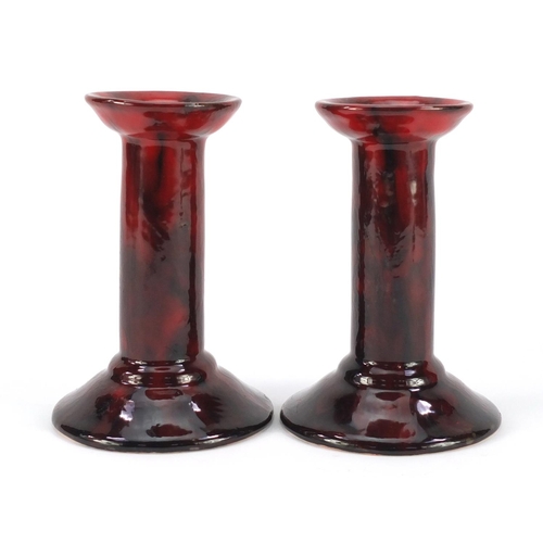 3484 - Pair of Royal Doulton flambe candlesticks by Charles Noke and Harry Nixon, each 14.5cm high