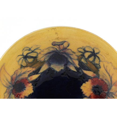 3481 - William Moorcroft pottery shallow bowl, hand painted in the Freesia pattern onto a blue and cream gr... 