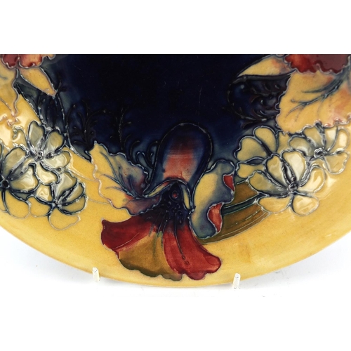 3481 - William Moorcroft pottery shallow bowl, hand painted in the Freesia pattern onto a blue and cream gr... 