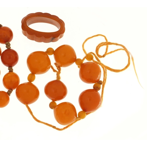 3143 - Two butterscotch amber coloured bead necklaces and ring, the largest necklace 50cm in length, 58.4g