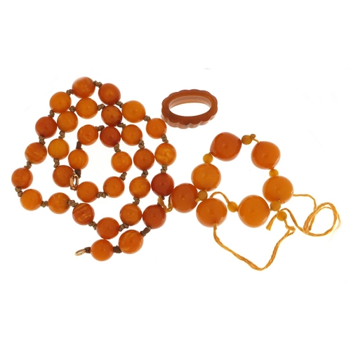 3143 - Two butterscotch amber coloured bead necklaces and ring, the largest necklace 50cm in length, 58.4g