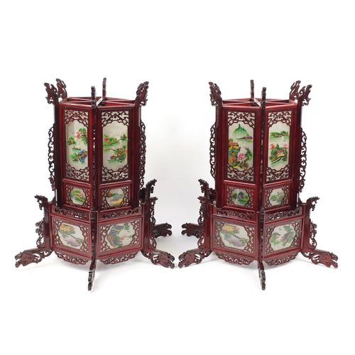 3946 - Pair of Chinese carved wood hanging lanterns with panels, each decorated with landscapes, 75cm high