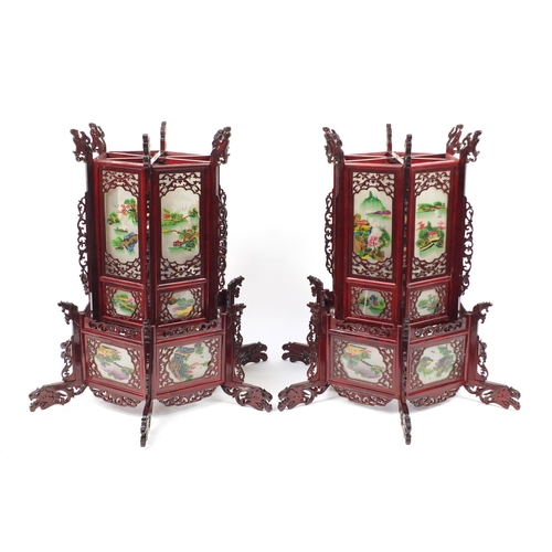 3946 - Pair of Chinese carved wood hanging lanterns with panels, each decorated with landscapes, 75cm high