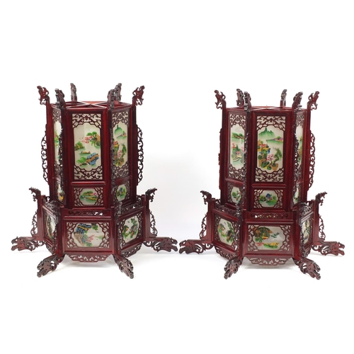 3946 - Pair of Chinese carved wood hanging lanterns with panels, each decorated with landscapes, 75cm high