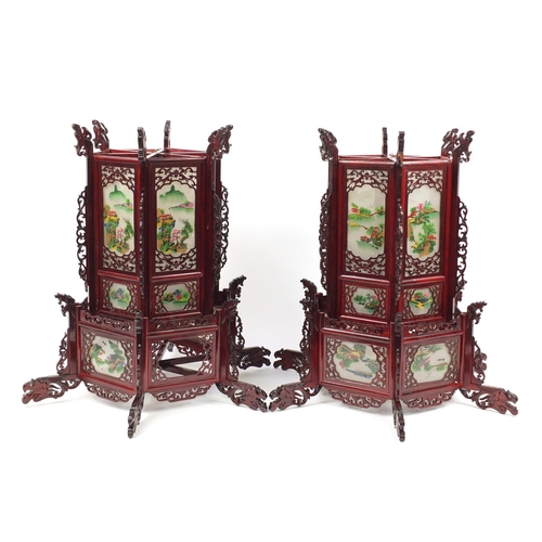 3946 - Pair of Chinese carved wood hanging lanterns with panels, each decorated with landscapes, 75cm high