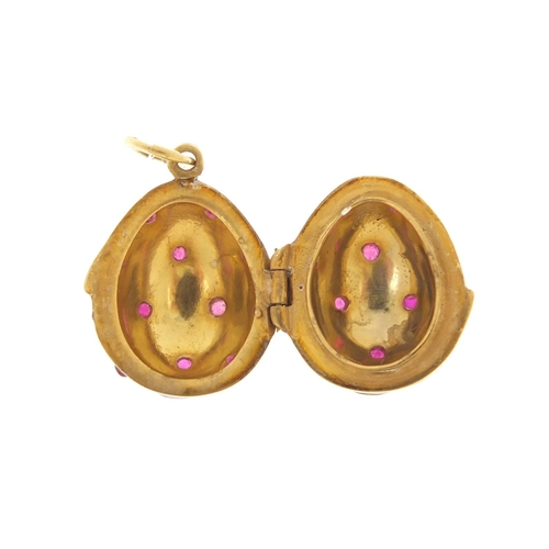 3374 - Russian silver gilt and enamel egg pendant, set with garnets, 2.6cm in length, 6.4g